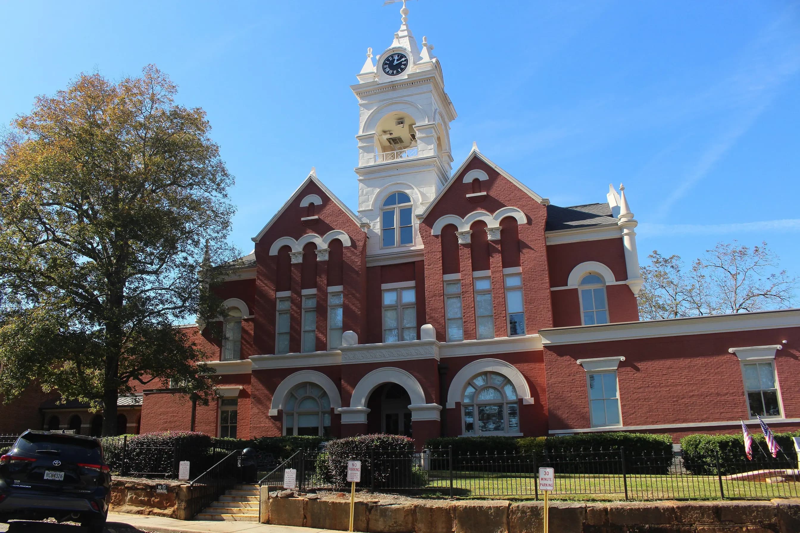 The red-brick Jones County Courthouse in Gray, Georgia, with its white clock tower against a blue sky.