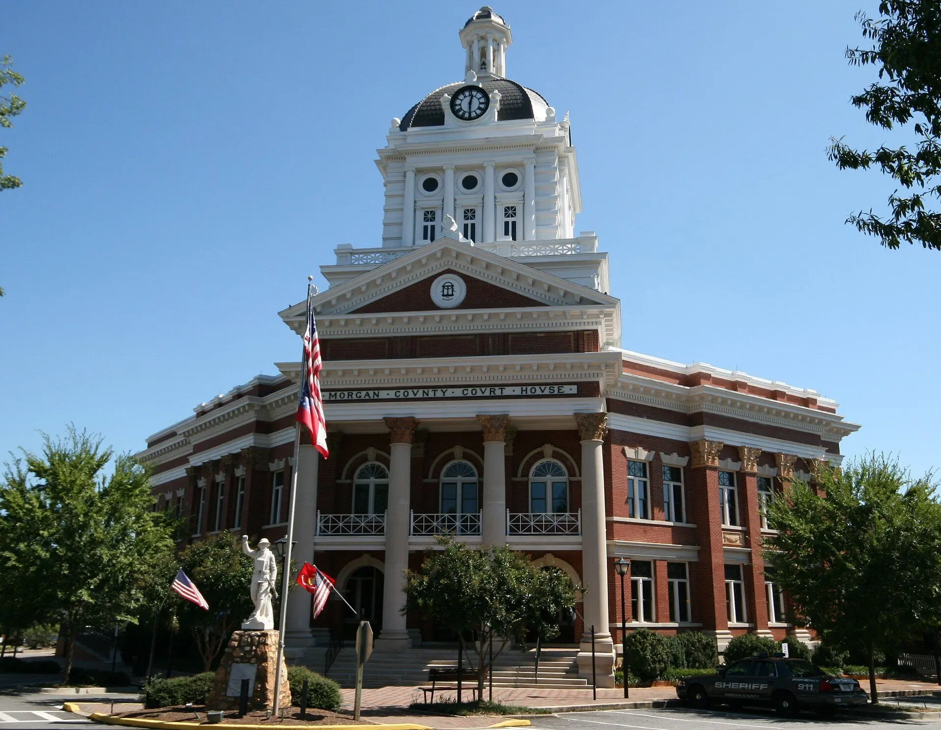 The domed, columned Morgan County Courthouse in Madison, Georgia, against a deep blue sky.