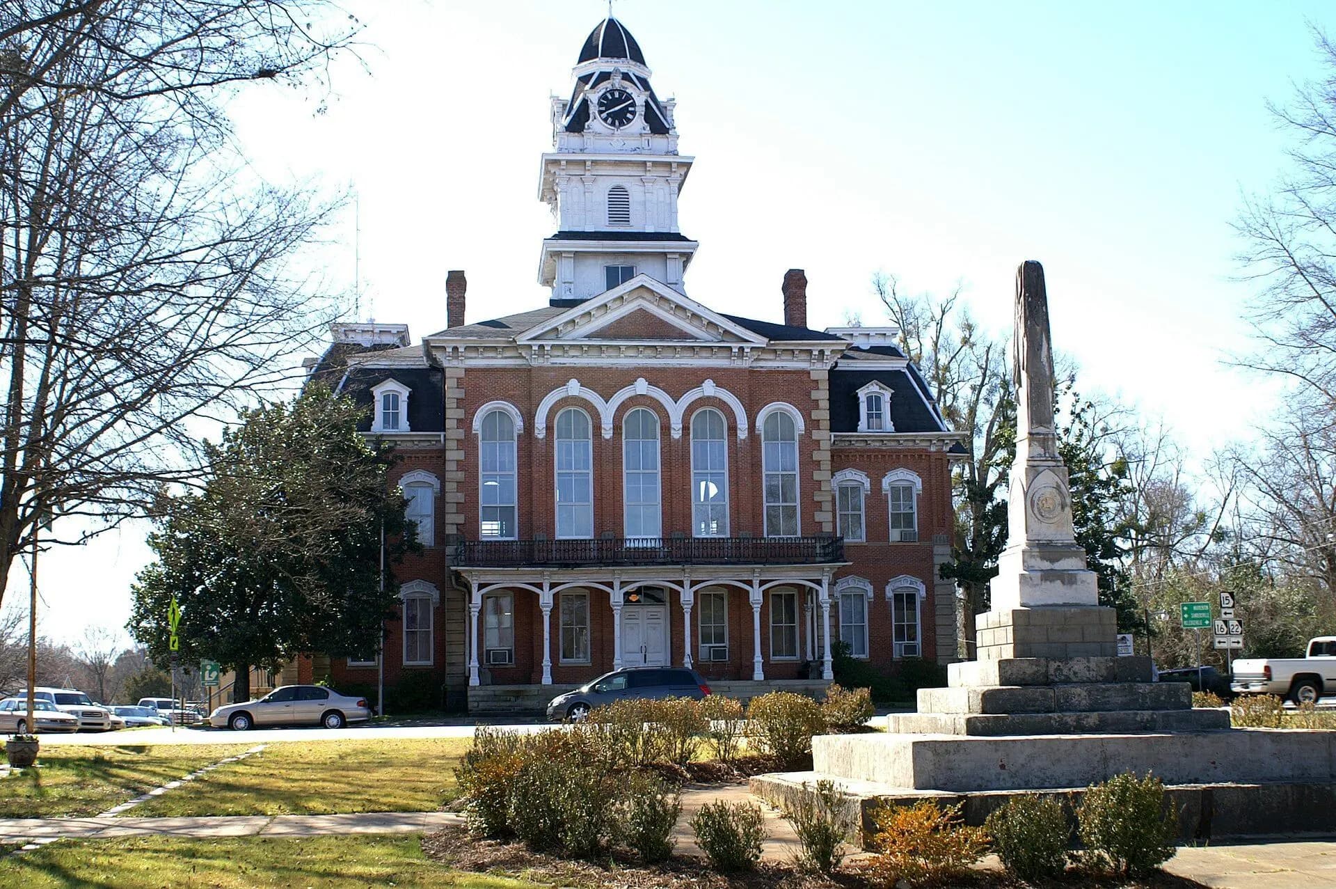 The Second Empire Hancock County Courthouse in Sparta, Georgia, with its clock tower and a monument on the square.
